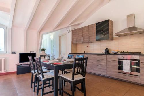 a kitchen with a dining room table and chairs at Appartamento Villa Principessa in Arco