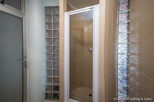una doccia con una porta in vetro in un bagno di Lazy Lizard 41 - with Inverter a Umdloti