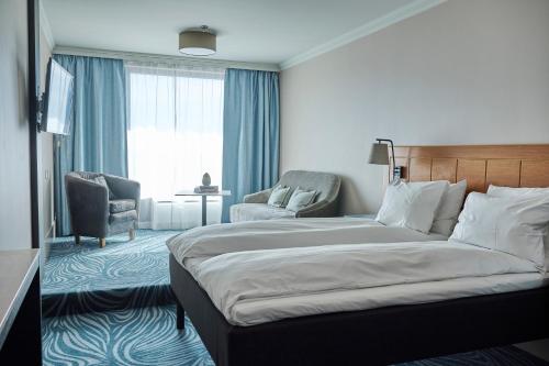 a hotel room with a bed and a chair at Hotel Klubben in Tønsberg