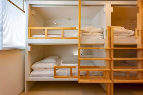 a room with bunk beds with towels in it at plat hostel keikyu sapporo sky in Sapporo