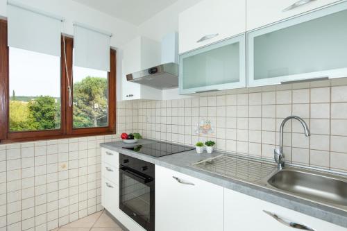 a kitchen with white appliances and a sink at Apartments Tonica in Malinska