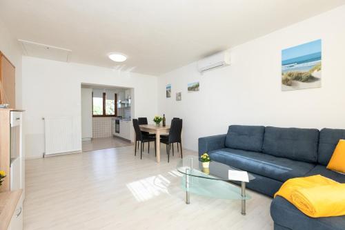 a living room with a blue couch and a table at Apartments Tonica in Malinska