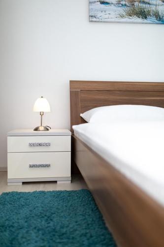 a bedroom with a white bed and a green rug at Apartments Tonica in Malinska