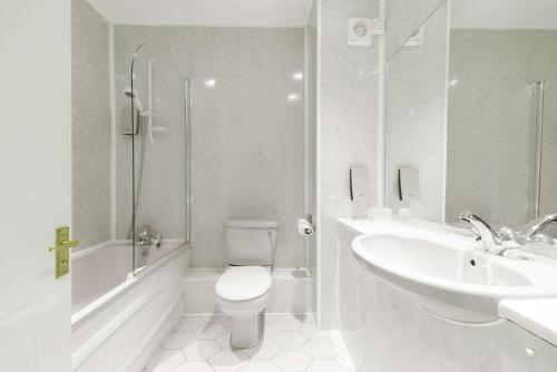 a bathroom with a sink, toilet and bathtub at Quality Hotel Coventry in Coventry