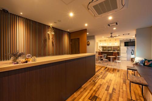 a kitchen and living room with a bar and a dining room at plat hostel keikyu sapporo sky in Sapporo