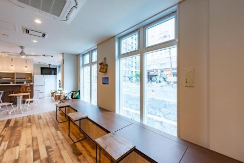 a room with a table and a large window at plat hostel keikyu sapporo sky in Sapporo