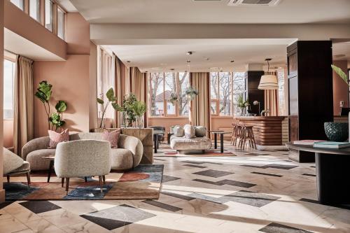 eine Lobby mit Sofas und Stühlen sowie ein Wohnzimmer in der Unterkunft Hotel Klubben in Tønsberg