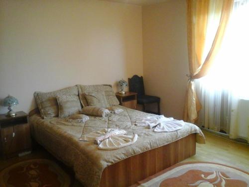 a bedroom with a bed with towels on it at Pensiunea Georgiana in Şieu