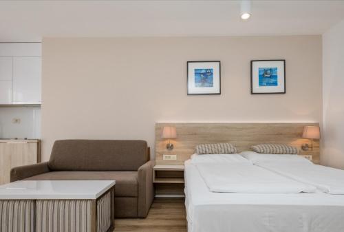una habitación de hotel con 2 camas y una silla en B&B Vila Sabbia, en Lopar