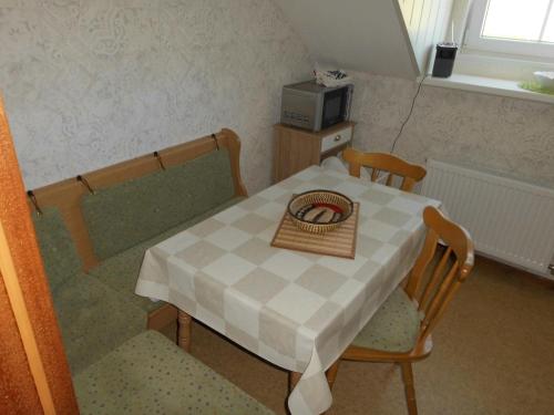 einen Tisch und Stühle mit einem Tisch und einer Mikrowelle in der Unterkunft Ferienwohnung Windten in Braunlage