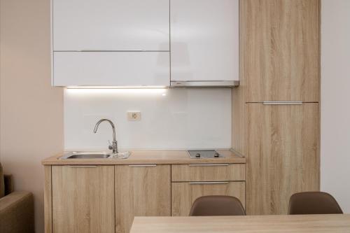 a kitchen with a sink and a counter with chairs at B&B Vila Sabbia in Lopar