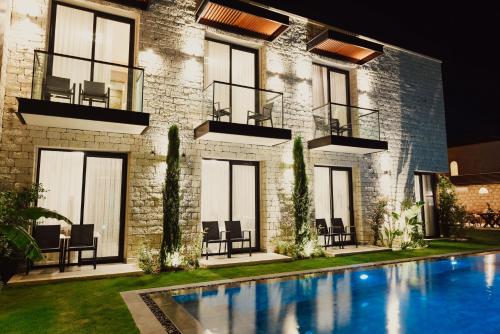 a house with a swimming pool in front of a building at Enso Alaçatı in Cesme