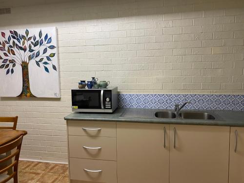 a kitchen with a sink and a microwave on a counter at The Old Butter Factory at Springhurst Estate in Springhurst