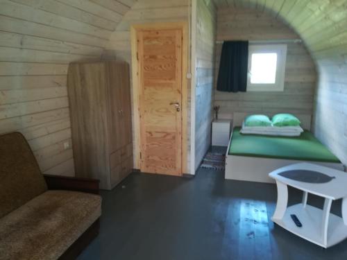 ein Schlafzimmer mit einem Bett in einem kleinen Zimmer in der Unterkunft Nameliai Žuvėdra in Šventoji