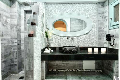 a bathroom with a large mirror and a sink at Anastasia Princess Luxury Residence & Spa- Adults Only in Perissa