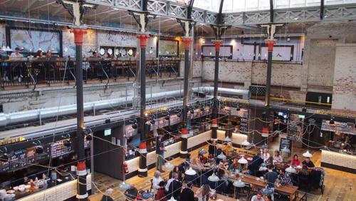 a group of people sitting in a large building at Lewis Apartment in the Heart of the Northern Quarter sleeps up to 12 in Manchester