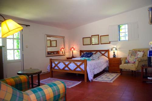 a bedroom with a bed and a couch and a chair at Quinta do Chaparrinho in Sardoal