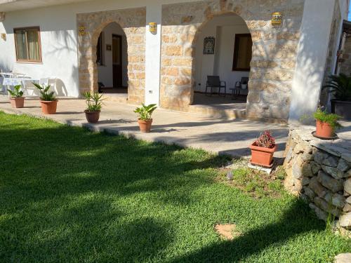 a house with a yard with potted plants at Villa Piruzzu CV Torre Mulinazzo app P in Cinisi