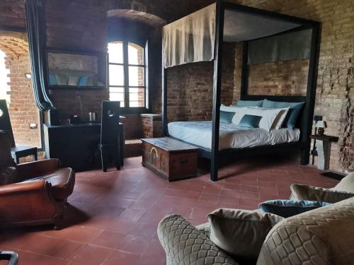 ein Schlafzimmer mit einem Himmelbett und einem Sofa in der Unterkunft Rocca di Arignano in Arignano