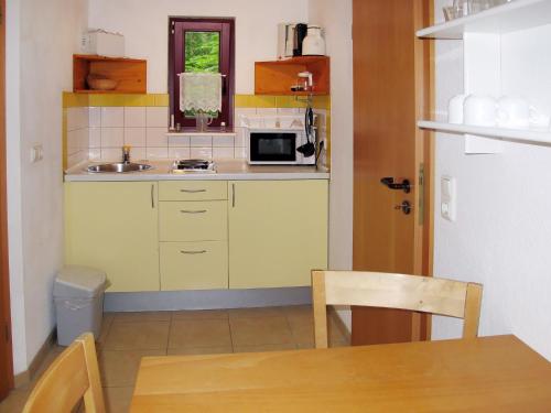 a small kitchen with a sink and a microwave at Holiday Home Silz am Fleesensee-1 by Interhome in Silz
