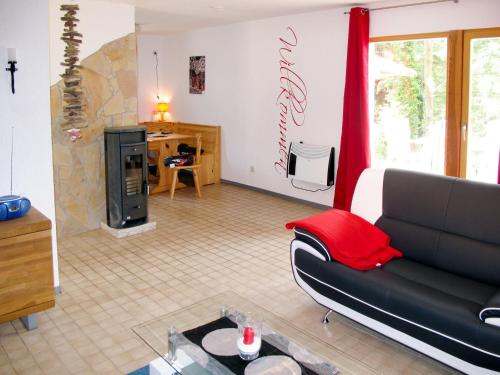 ヒンメルプフォルトにあるHoliday Home Waldhäuser-2 by Interhomeのリビングルーム(黒いソファ、暖炉付)
