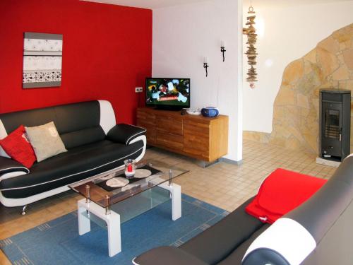 ヒンメルプフォルトにあるHoliday Home Waldhäuser-2 by Interhomeの赤い壁のリビングルーム(黒いソファ付)