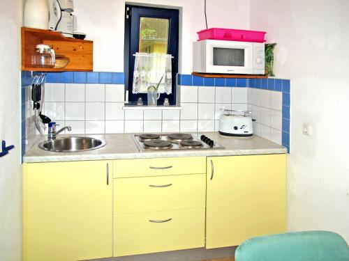 una pequeña cocina con fregadero y microondas en Holiday Home Silz am Fleesensee-2 by Interhome, en Silz