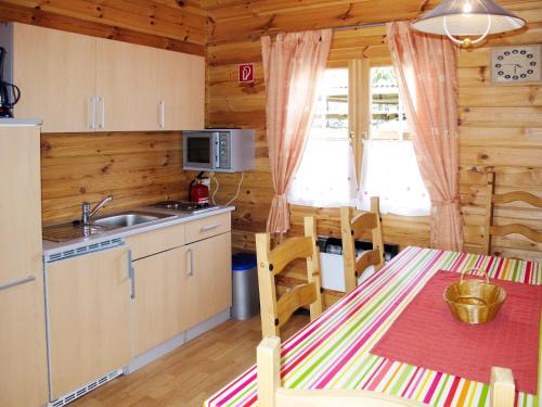 a kitchen and dining room with a table in a cabin at Holiday Home Zum Stolpseefischer by Interhome in Himmelpfort