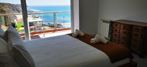 a bedroom with a large bed with a view of the ocean at Mega Ocean Magoito - Sintra in Sintra