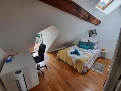 - une chambre mansardée avec un lit et un bureau dans l'établissement BNB Le COCON, Cœur Historique d'Orléans, 5' Train Station, à Orléans