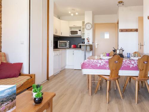 een keuken en een woonkamer met een tafel en stoelen bij Apartment Bâtiment B-9 by Interhome in Le Corbier
