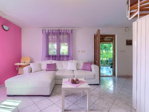 a living room with a white couch and purple walls at Holiday Home Nikolina - Roj412 by Interhome in Sveti Petar u Šumi