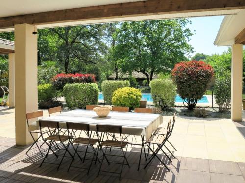 a table and chairs on a patio with a pool at Holiday Home Eugénie - GHP190 by Interhome in Grayan-et-lʼHôpital