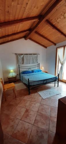 1 dormitorio con 1 cama en una habitación con techos de madera en Casa Grazia e Enrico, en Chia