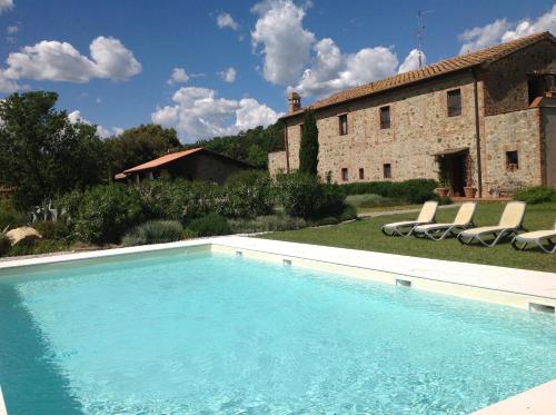 a large swimming pool in front of a building at Antico Casale L'impostino in Civitella Marittima