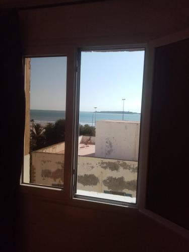 a window in a room with a view of the ocean at Résidence Louzani in Essaouira