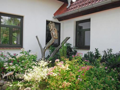 a statue in a garden in front of a house at Apartment Rügen by Interhome in Dargun