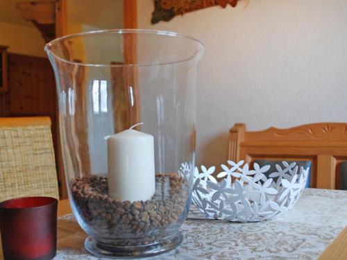 a candle in a glass vase on a table at Apartment Rügen by Interhome in Dargun