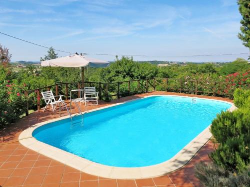 a swimming pool with a table and chairs and an umbrella at Holiday Home Le Rose Rosse by Interhome in Grazzano Badoglio