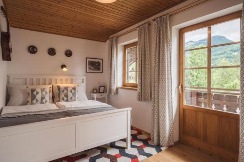 a bedroom with a bed and a window at Ferienwohnungen Villa Salzweg in Bad Goisern