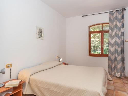 a white bedroom with a bed and a window at Apartment Villa Katia by Interhome in La Ciaccia