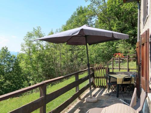 a patio with a table and an umbrella on a fence at Apartment Baita dei Nonni-2 by Interhome in Livo