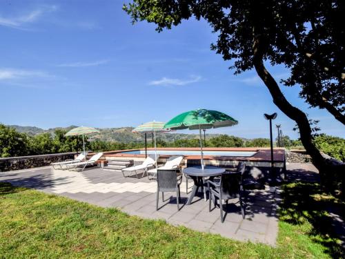 a patio with a table and chairs and umbrellas at Apartment Serena by Interhome in Piedimonte Etneo