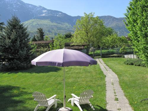 dos sillas y un paraguas en el césped en Holiday Home Lucrezia - CCO310 by Interhome en Colico