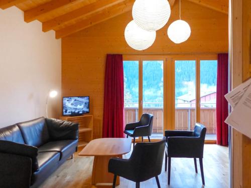un salon avec un canapé, une table et des chaises dans l'établissement Apartment Chalet Almisgässli by Interhome, à Grindelwald