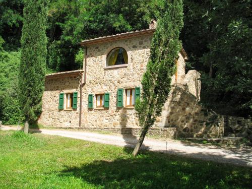 Podere CamininoにあるHoliday Home Il Pozzo by Interhomeの緑窓と木を持つ石造りの家