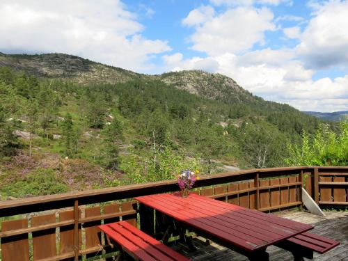 a red picnic table on a deck with a view of a mountain at Holiday Home Kvila by Interhome in Øyuvstad