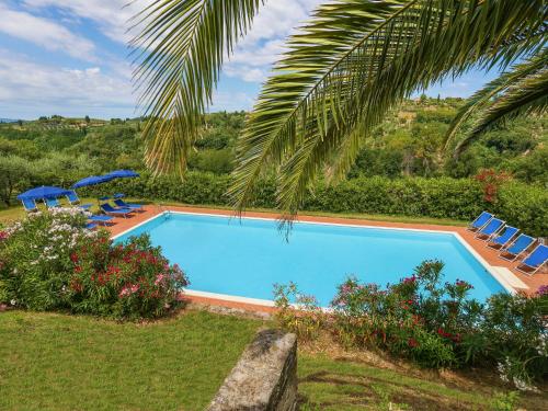 a swimming pool with chairs and a palm tree at Holiday Home Terra Bianca - PAA136 by Interhome in Palaia
