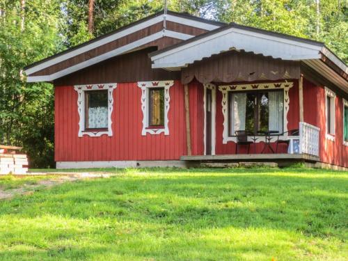JuhanalaにあるHoliday Home Kuusela by Interhomeの前に緑の芝生がある赤い家