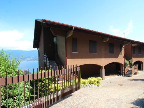 een huis met een hek ervoor bij Apartment Roccolo Miralago by Interhome in Cerro Lago Maggiore